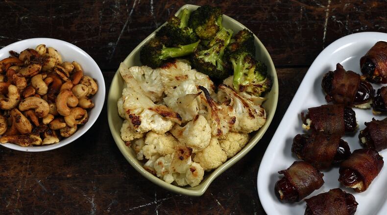 Three of the beer snack choices: beer nuts, from left, garlic and anchovy-roasted cauliflower and broccoli, and cheese-filled, bacon-wrapped dates. (Terrence Antonio James/Chicago Tribune/TNS)