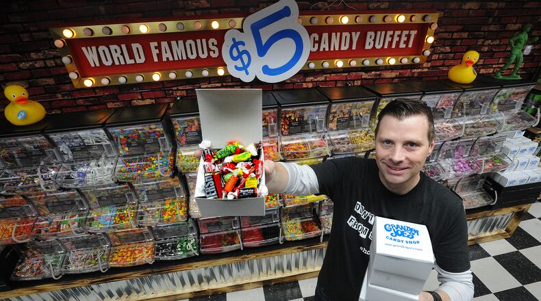 T.J. Parks, retail operations manager for Grandpa Joe's Candy Shop, stands by the newly renovated Miamisburg stores world famous $5 candy buffet. MARSHALL GORBY/STAFF