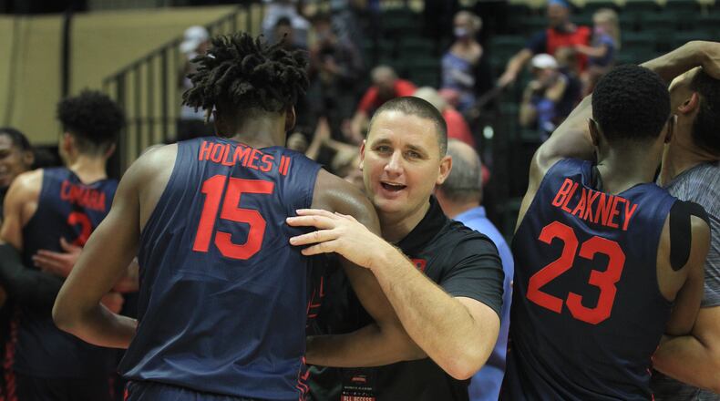 Dayton's Neil Sullivan hugs DaRon Holmes II after a victory against Kansas in the semifinals of the ESPN Events Invitational on Friday, Nov. 26, 2021, at HP Fieldhouse in Kissimmee, Fla. David Jablonski/Staff