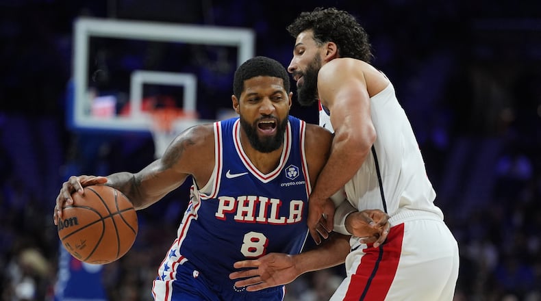Philadelphia 76ers' Paul George (8) tries to get a shot past Washington Wizards' Anthony Gill during the second half of an NBA basketball game Wednesday, Jan. 7, 2026, in Philadelphia. (AP Photo/Matt Rourke)