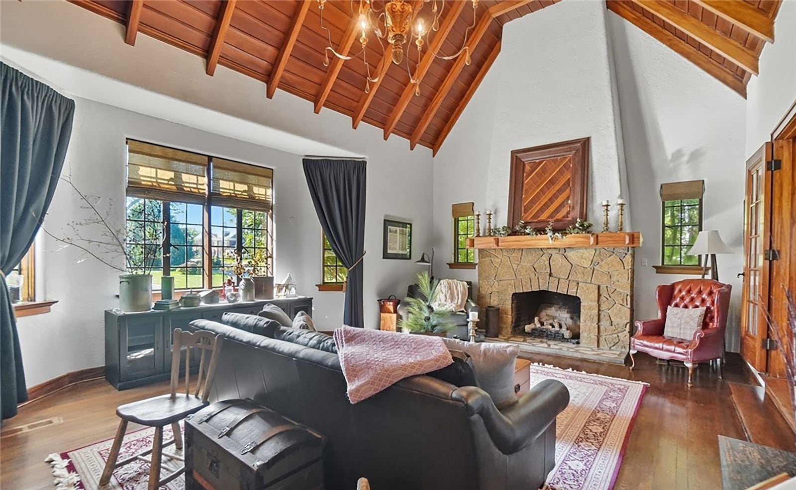 The living room has a vaulted wood and beamed ceiling and a stone fireplace with wood mantel. CONTRIBUTED