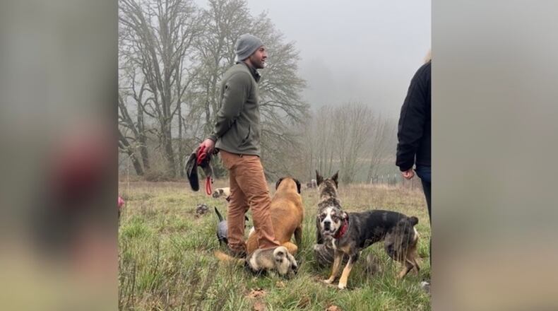 Lee Asher, founder of the Asher House, with "Hank" and other members of the dog pack at his animal sanctuary in Oregon. Asher adopted Hank from SICSA in Washington Twp. CONTRIBUTED
