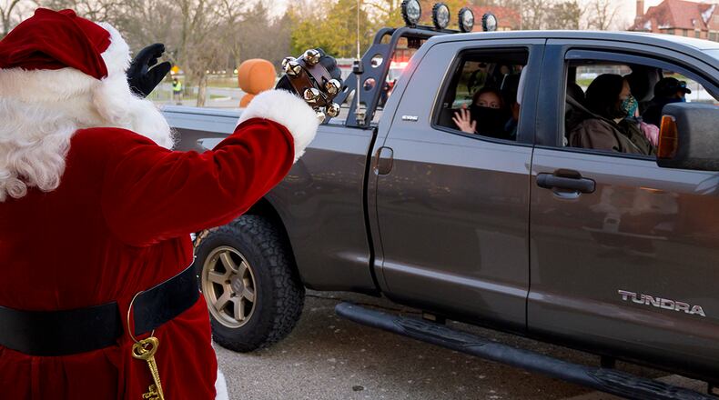 Santa Claus waves to children in a passing car during the 2020 Tree Lighting drive-thru event hosted by the 88th Force Support Squadron at Wright-Patterson Air Force Base Dec. 2. U.S. AIR FORCE PHOTO/WESLEY FARNSWORTH