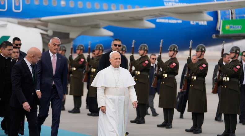 Pope Leo XIV walks as he is welcomed upon his arrival at Esenboga International Airport in Ankara, Turkey, Thursday, Nov. 27, 2025, marking the beginning of his first foreign trip. (AP Photo/Khalil Hamra)