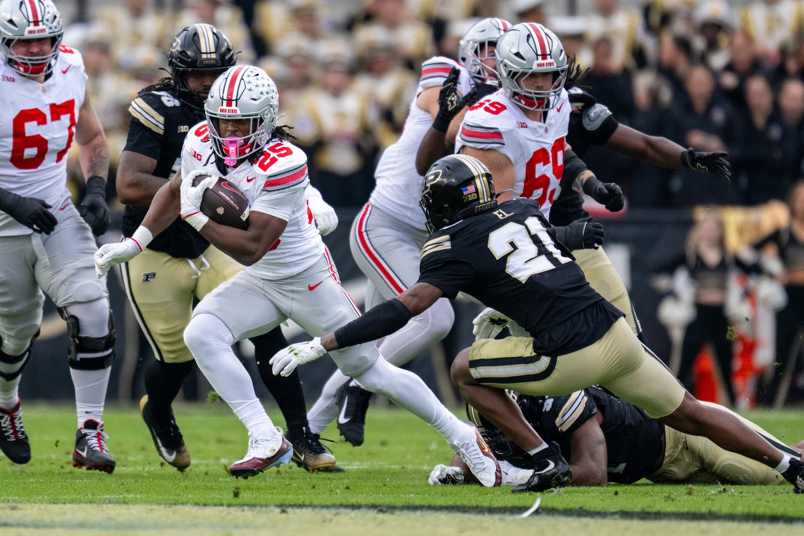 Ohio State running back Bo Jackson (25) makes a run around the reach of Purdue defensive back Tahj Ra-El (21) during the first half of an NCAA college football game, Saturday, Nov. 8, 2025, in West Lafayette, Ind. (AP Photo/Doug McSchooler)