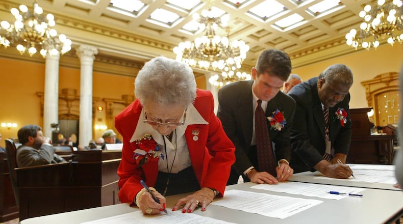 Members of Ohio’s delegation to the Electoral College certify their votes during the voting ceremony at the Statehouse on Dec. 13, 2004. The Ohio delegation chose President George W. Bush that year. (AP Photo/Will Shilling)