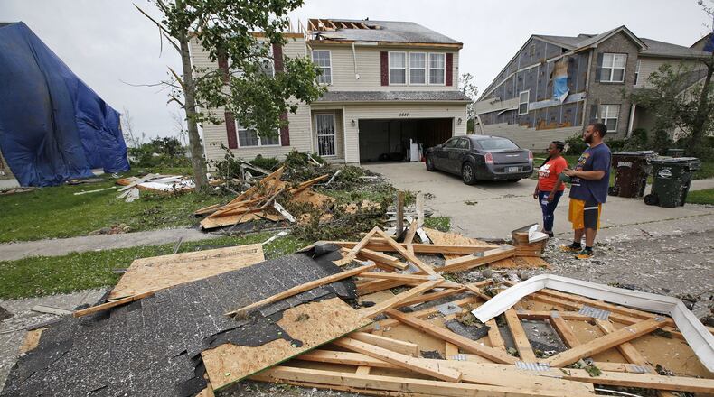 Trotwood residents Ryan an Danielle Johnson rode out the tornado in the basement on Monday night and discovered half of their roof missing on Wolf Creek Run. TY GREENLEES / STAFF