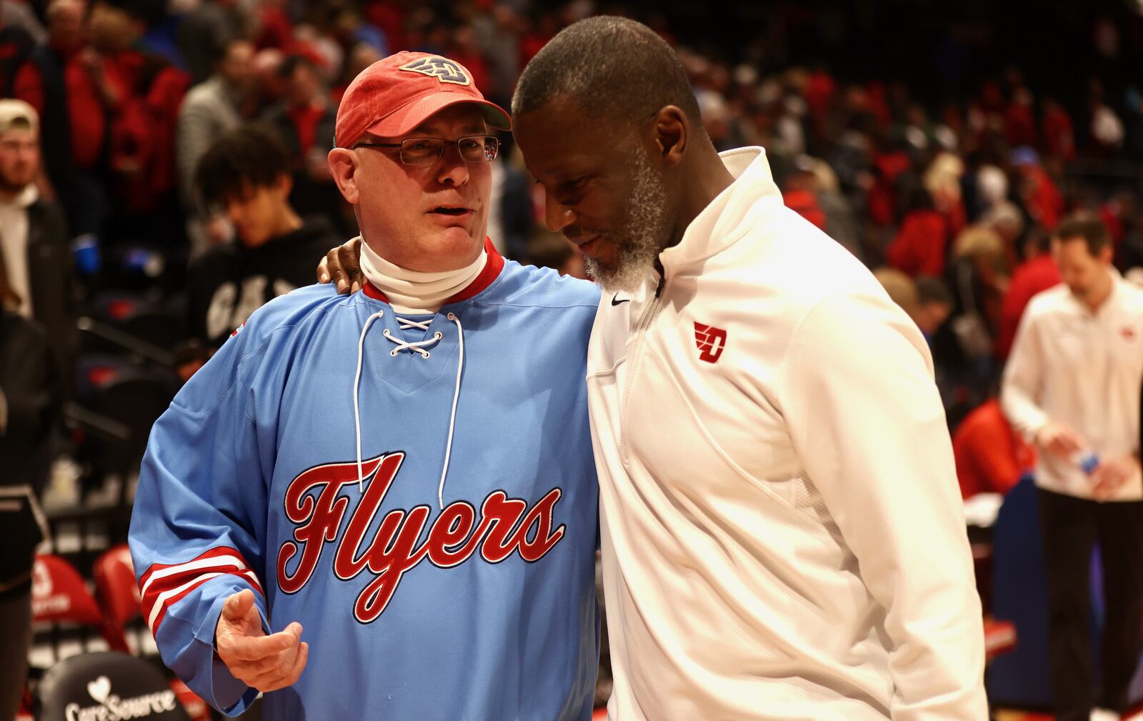 University of Dayton President Eric Spina leaves the court coach Anthony Grant after a victory against Saint Louis on Friday, Feb. 10, 2023, at UD Arena. David Jablonski/Staff