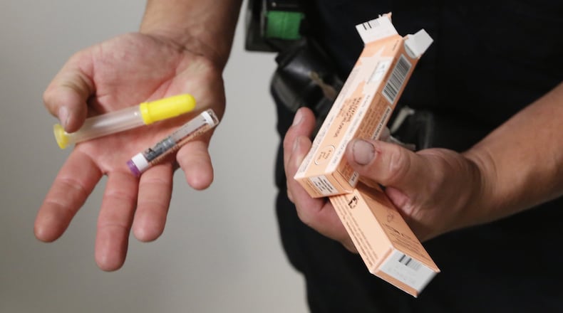 A Dayton Police Officer holds Narcan. With the accessibility of Naloxone, the number of overdose deaths have lessened. CONTRIBUTED