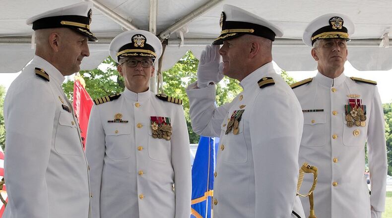 Capt. Rees Lee (front left) is relieved by Capt. Matthew Hebert (front right) who assumed the role of commanding officer, Naval Medical Research Unit Dayton Aug. 6. Capt. Adam Armstrong, commander, Naval Medical Research Center (middle), was the immediate superior in command and Rear Adm. Paul Pearigen, commander, Navy Medicine West (back right) was the presiding officer of the ceremony. (U.S. Air Force photo/Michelle Gigante)