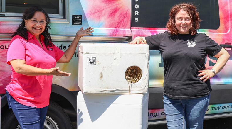 Augustina DeLeon (left), owner of Frios Popsicles, poses in front of one of her trucks with Chris Banks (right), who founded the Dayton Community Cat Project. DeLeon has been selected as a Dayton Daily News Community Gem for donating Styrofoam containers she uses to store popsicles to the charity, which converts them into shelters for stray cats. BRYANT BILLING / STAFF