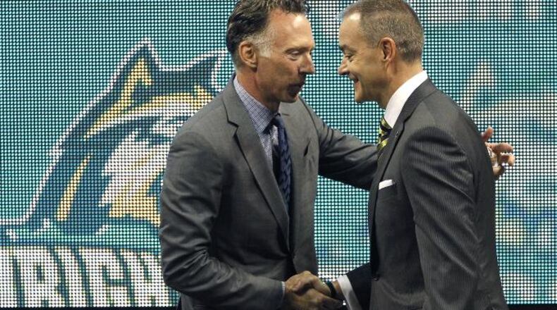 Wright State University Athletics Director Bob Grant (left) introduces Scott Nagy, the new WSU head men’s basketball coach during an April press conference. Grant expects Nagy to have a positive effect on the bottom line of WSU athletics, which has run a deficit every year since 2007. LISA POWELL / STAFF