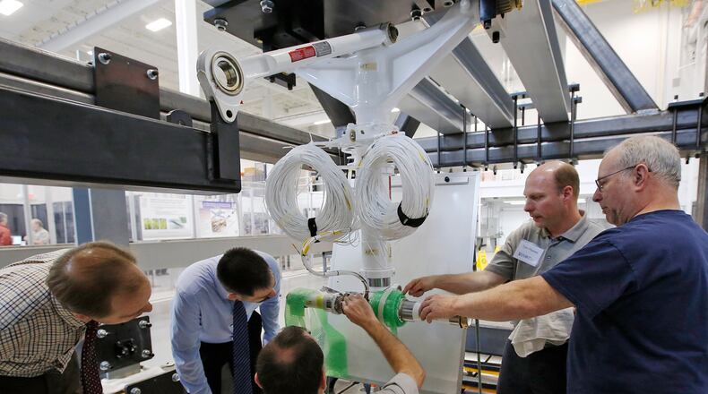 The University of Dayton Research Institute will have a part in an $8 million additive manufacturing research project. In this April 2016 photo, engineers and visitors at the UDRI Structures & Materials Assessment, Research and Test (SMART) Lab discuss sensors used to test the landing gear of a Lockheed C-130 Hercules cargo plane. FILE