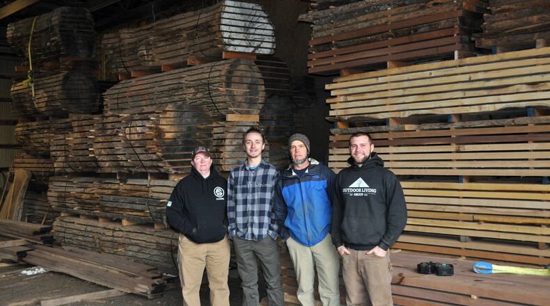 Staff from Moraine based Outdoor Living Group stand in front of processed lumber. The company’s sawmill operation helped people clean up their yards after last year’s tornadoes. L-R Chris Trembley, Jake Kingery, Tony Niekamp, Barrett Niekamp CONTRIBUTED