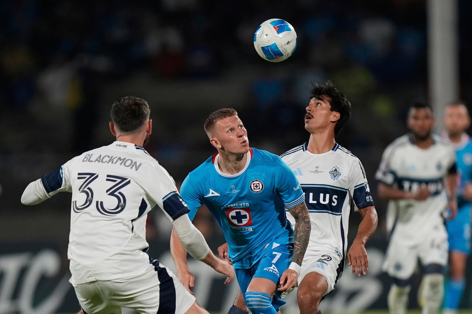 Mateusz Bogusz of Mexico's Cruz Azul, center, competes for the ball against Mathias Laborda, right, and Tristan Blackmon of Canada's Vancouver Whitecaps during the CONCACAF Champions Cup final soccer match in Mexico City, Sunday, June 1, 2025. (AP Photo/Fernando Llano)