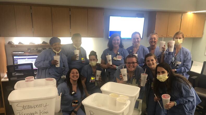 Fruit For All Reasons is celebrating its 20th year in business in June. Owner Byron Ingram has been providing free smoothies to local hospital staff workers. Pictured are workers from Miami Valley Hospital’s Berry Center receiving smoothies from the business.