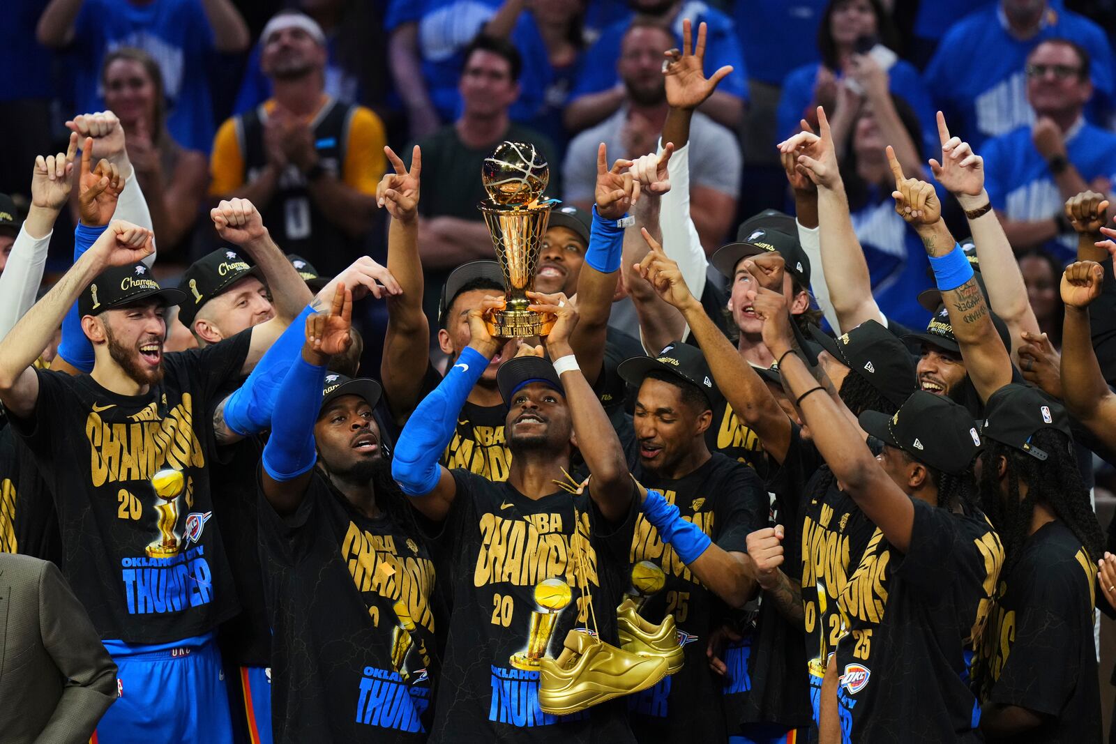 Oklahoma City Thunder guard Shai Gilgeous-Alexander, center, holds up the MVP trophy as he celebrates with his team after they won the NBA basketball championship with a Game 7 victory against the Indiana Pacers Sunday, June 22, 2025, in Oklahoma City. (AP Photo/Nate Billings)