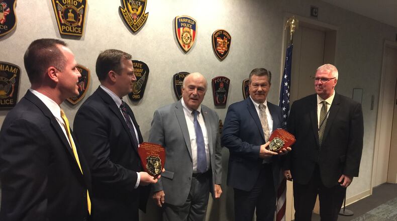 Butler County Prosecutor Michael Gmoser recognized Middletown police Detective Steve Winters and Hamilton police Detective John Habig for their tireless work prosecuting scammers and thefts from the elderly. Gmoser called it the silent second epidemic in Butler County. The detectives were recognized Tuesday at the Prosecutor’s Office. From left, Hamilton police Chief Craig Bucheit, Hamilton police Detective John Habig, Prosecutor Michael Gmoser, Middletown police Detective Steve Winters, and Middletown police Chief Rodney Muterspaw. ED RICHTER/STAFF