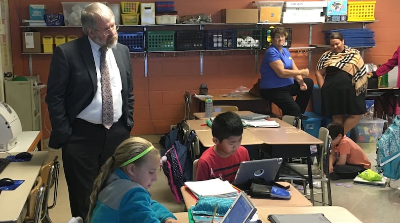 State school superintendent Paolo DeMaria (standing, left) watches students at Shaw Elementary in Beavercreek work on a math activity that was integrated with their PAX behavior program last month. JEREMY P. KELLEY/STAFF