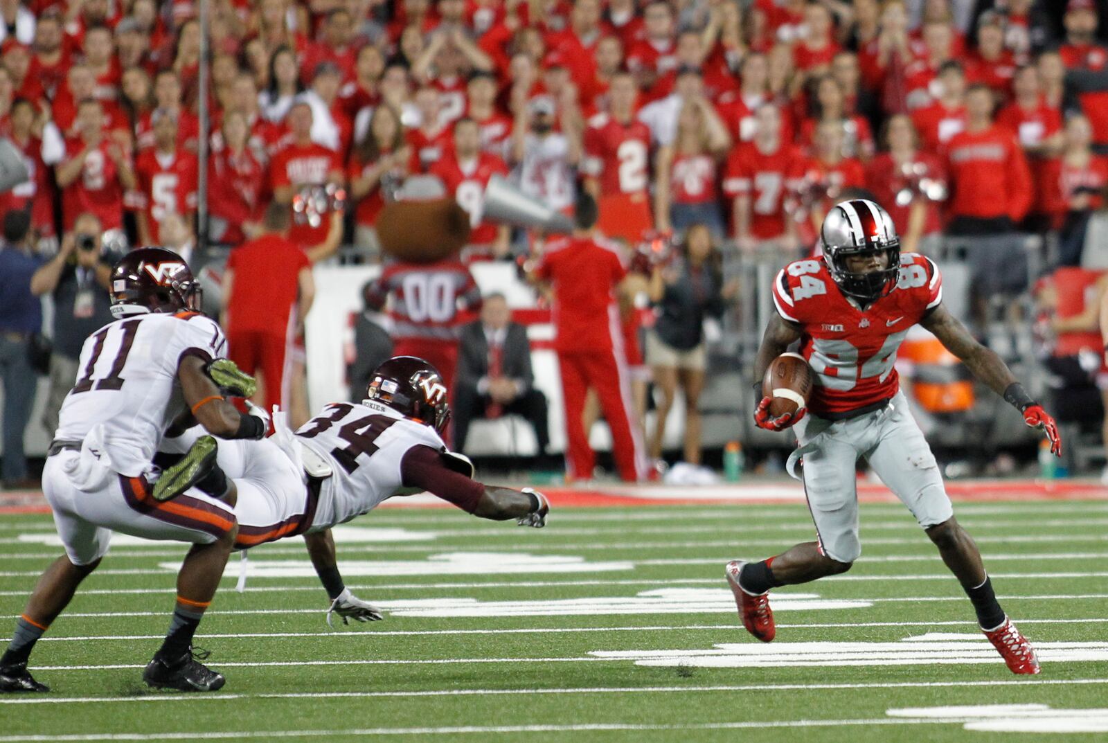 Ohio State’s Corey Smith, right, runs with the ball after a catch as Virginia Tech’s Kendall Fuller (11) and Kyshoen Jarrett (34) pursue him on Saturday, Sept. 6, 2014, at Ohio Stadium in Columbus. David Jablonski/Staff