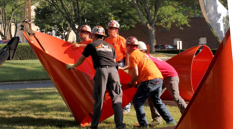 “Firmament,” the bright orange sculpture of steel cylinders on the Dayton Art Institute grounds, was removed Monday, Aug. 23 for conservation work. The artwork, created by Alexander Liberman, has been part of the museum’s collection since 1976. It will be returned in November. ERIC BROCKMAN / DAYTON ART INSTITUTE