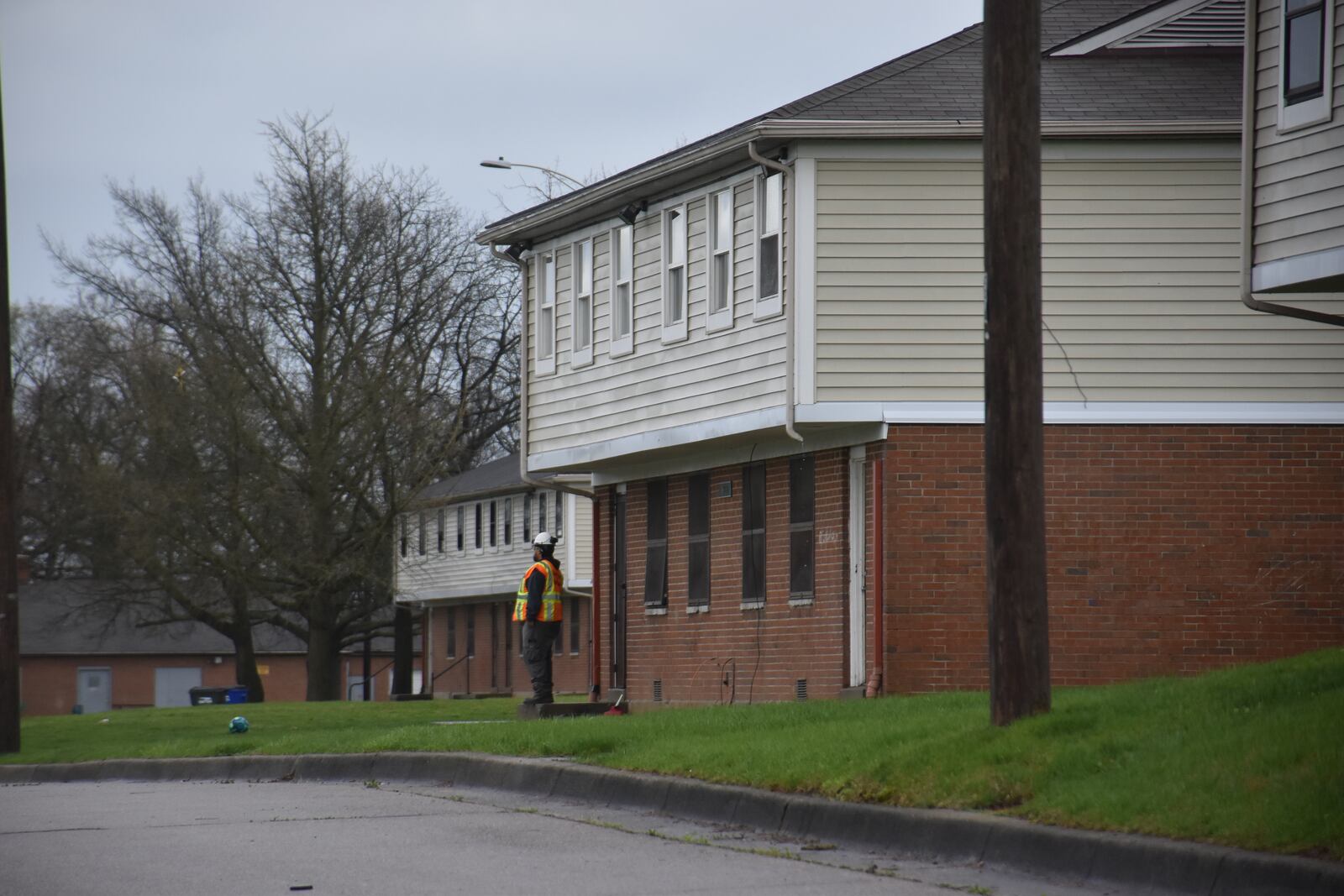 A worker stands outside of one of the Hilltop Homes apartment units in West Dayton. Greater Dayton Premier Management (GDPM) plans to demolish all 150 units in the public housing development. CORNELIUS FROLIK / STAFF