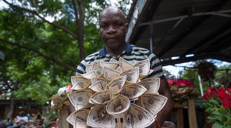Florist Tongai Mufandaedza holds a money bouquet designed for Valentine's Day at his stall in Harare, Zimbabwe, Tuesday, Feb. 10, 2026. (AP Photo/Aaron Ufumeli)