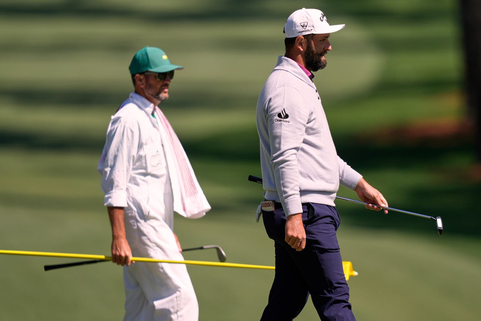 Jon Rahm, of Spain, right, and his caddie Adam Hayes, walk off the 10th green during a practice round at the Masters golf tournament, Tuesday, April 8, 2025, in Augusta, Ga. (AP Photo/Matt Slocum)