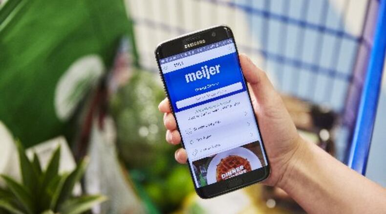 A Shipt employee navigates Meijer with a cart full of groceries. HANDOUT