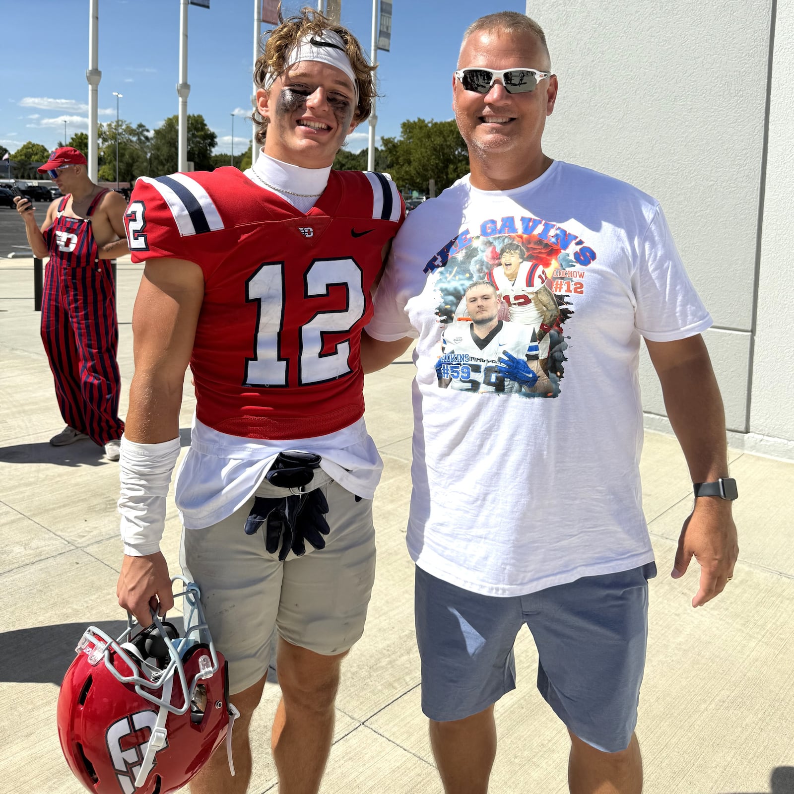 After leading the Flyers with nine catches for 83 yards and two touchdowns in a 38-0 victory over Thomas More University, receiver Gavin Lochow stands alongside Billy Seals, his high school football coach at Huntington High in West Virginia. Seals is wearing a special t-shirt he had made that pictured Lochow and his high school teammate, Gavin Adkins, who is a  defensive lineman at Thomas More. CONTRIBUTED PHOTO