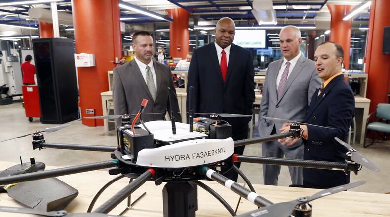 Andrew Shepherd, right, Executive Director & Chief Scientist, UAS, at Sinclair Community College, talks about a large octocopter drone used for research by students. With Shepherd from the left are: Jeff Miller, Chief Operating Officer, UAS, Sinclair, Maurice McDonald, EVP, Aerospace & Defense at the Dayton Development Coalition (DDC) and Scott Koorndyk, President of The Entrepreneurs Center. Sinclair announced on Wednesday that it was awarded a $545K grant to support UAS tech entrepreneurship. TY GREENLEES / STAFF