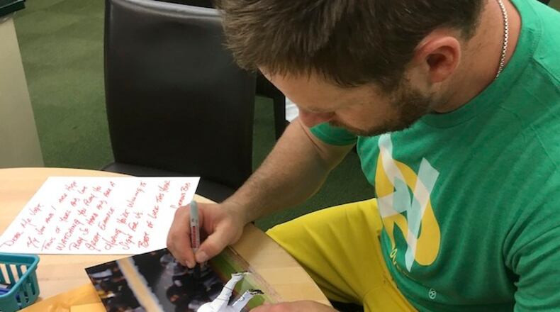 In this June 15, 2017, photo, then-Oakland Athletics catcher Stephen Vogt autographs fan mail before a baseball game between the Athletics and the New York Yankees in Oakland, Calif. Vogt recently got caught up on two years' worth of fan mail; he remembers being that child collecting autographs at every chance. (AP Photo/Janie McCauley)