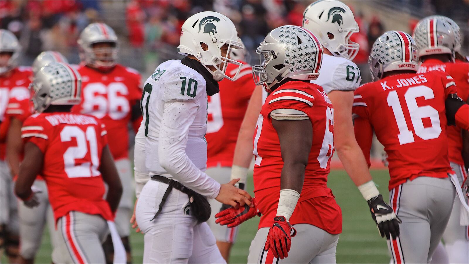 Wayne Warriors alumni Messiah deWeaver (left) and Robert Landers exchange a greeting during Ohio State's win over Michigan State on Saturday in Columbus.