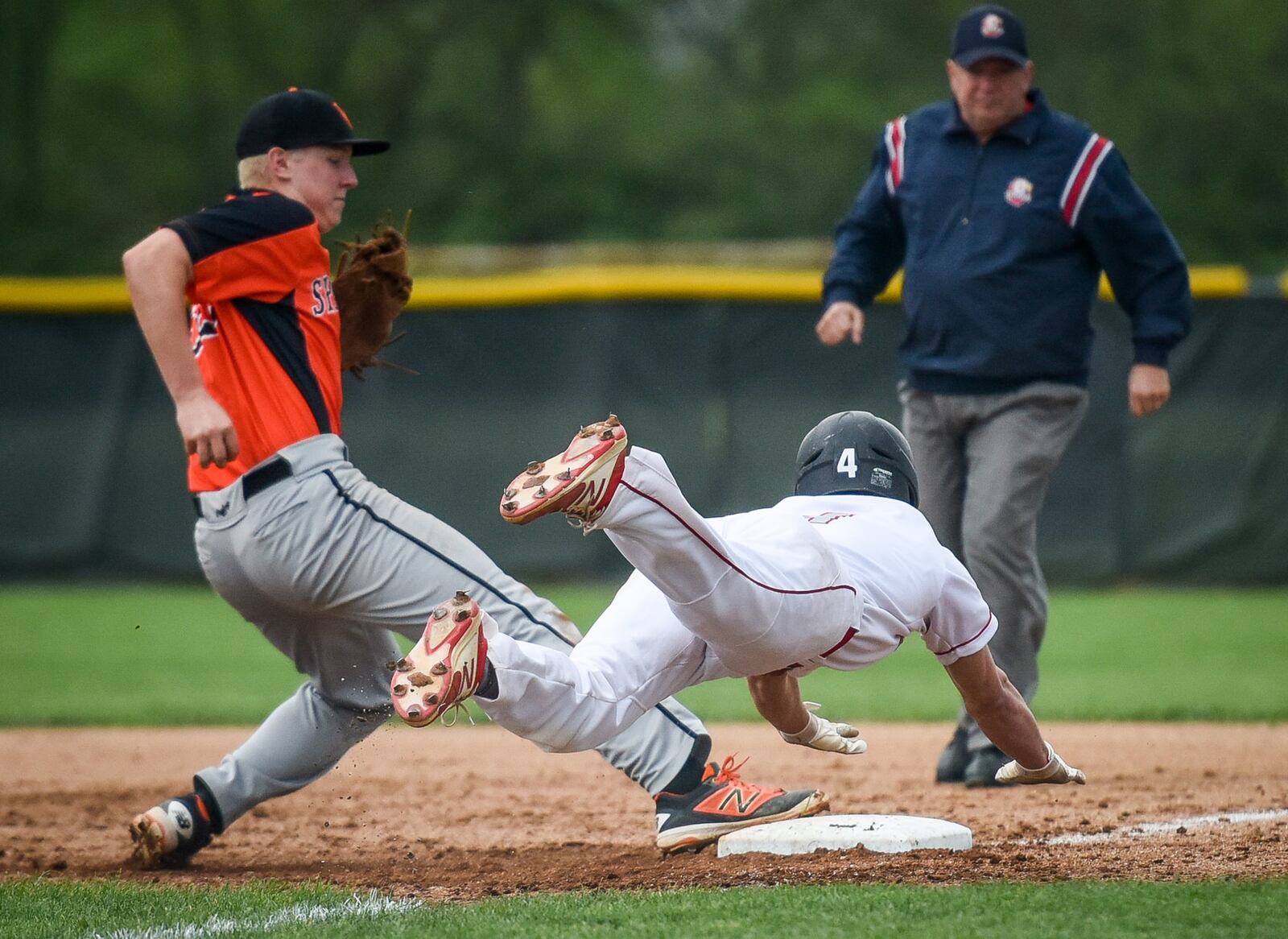 Carlisle’s Adam Goodpaster is called out as he dives into first base just after the base tag by Waynesville’s Tommy Isaacs during Monday’s game at Sam Franks Field in Carlisle. NICK GRAHAM/STAFF