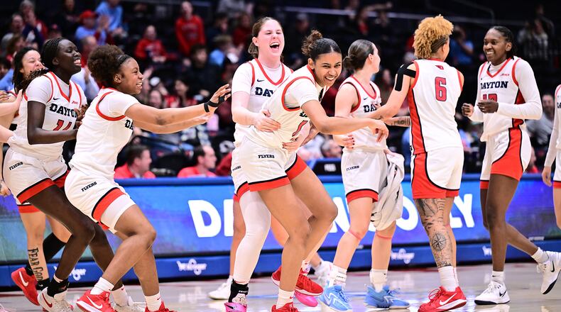 Teammates celebrate with Dayton's Jayda Johnson (center) during Wednesday night's game vs. St. Joseph's at UD Arena. Erick Schelkun/UD Athletics photo