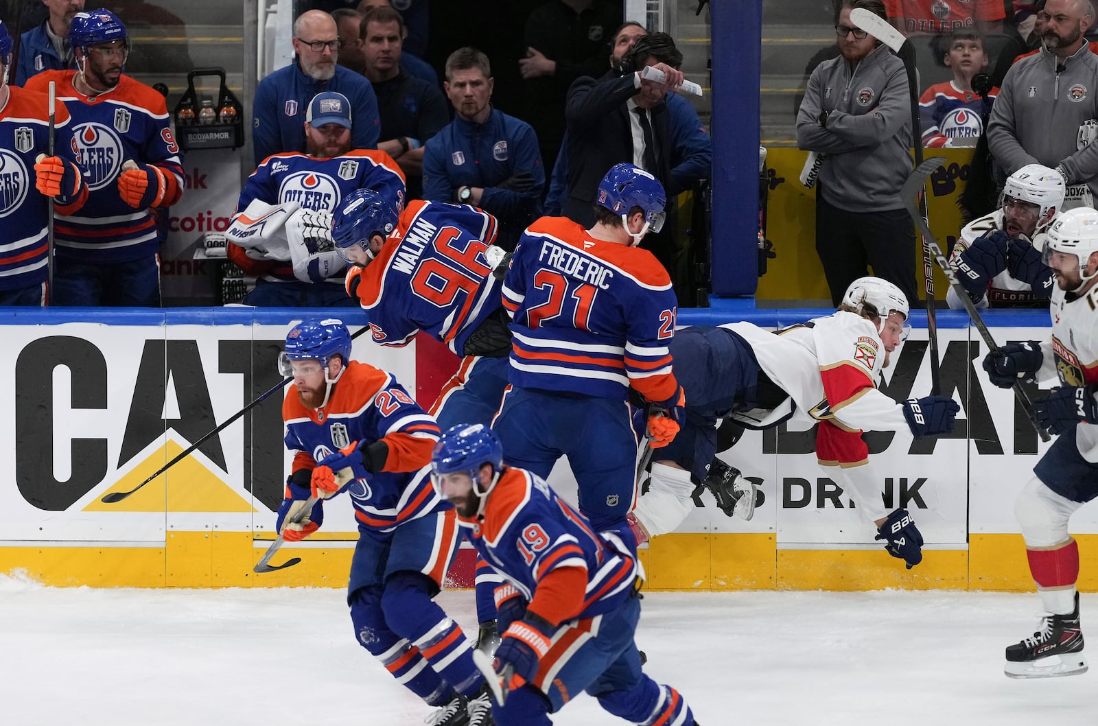 Edmonton Oilers' Jake Walman (96) checks Florida Panthers' Jesper Boqvist, back right, during the first period in Game 1 of the NHL Stanley Cup Final, in Edmonton, Alberta, on Wednesday, June 4, 2025. (Darryl Dyck/The Canadian Press via AP)