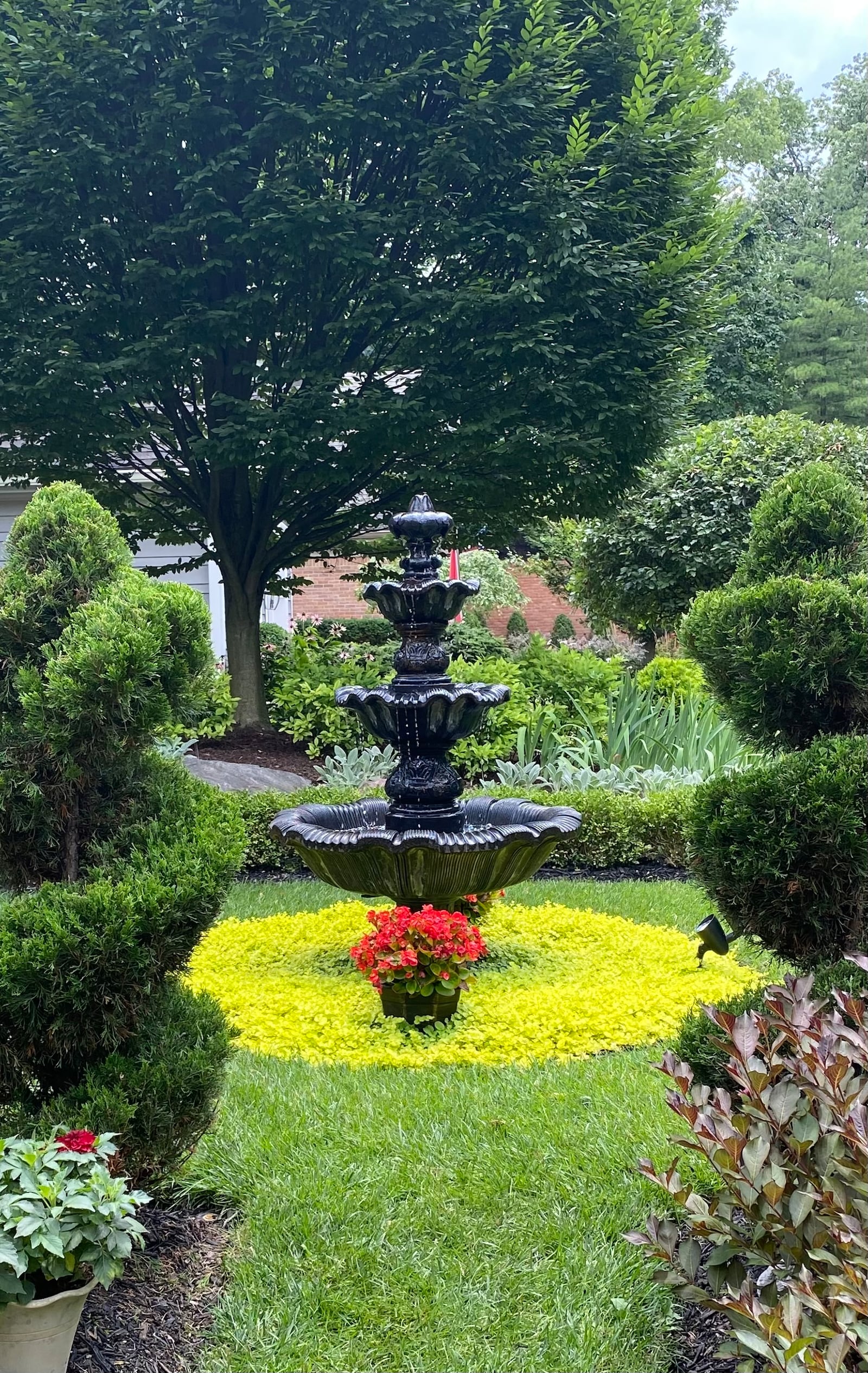 This homeowner included an antique wrought iron bench and three-tiered fountain to create the feel of a private French garden in her small front yard.