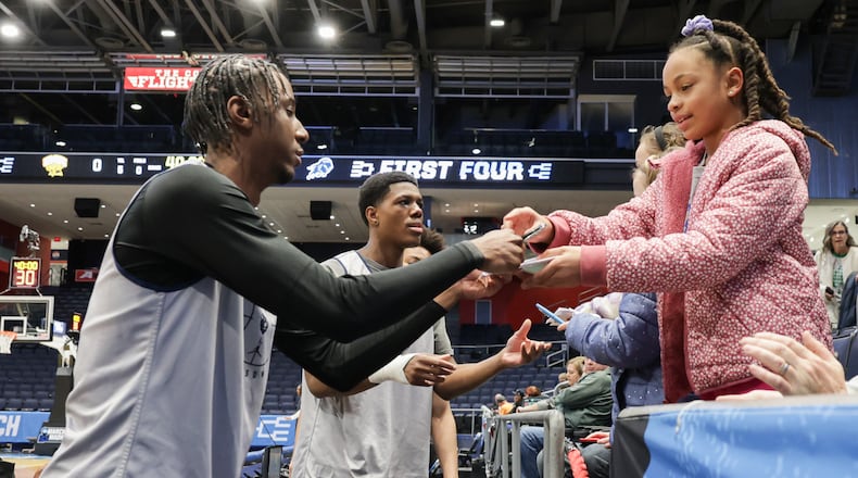 Howard University freshman guard Jeremiah Johnson hands an autograph back to Bren Knopp, of Miamisburg, during a practice on Monday, March 16 at University of Dayton Arena. Howard is one of eight teams participating in the NCAA First Four this week. Knopp's youth league team won its division in Dayton Metro. BRYANT BILLING / STAFF