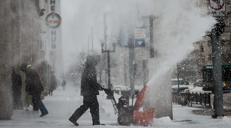 Juan Carlos blows snow on Main Street near The Hub in Dayton Friday December 23, 2022. Jim Noelker/Staff