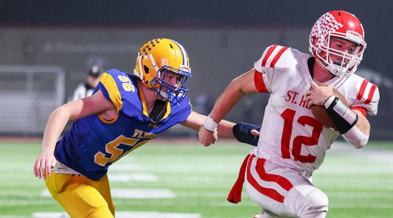 St. Henry senior quarterback Charlie Werling runs as Marion Local's Jacob Muhlenkamp tries to tackle during a touchdown run late in the second quarter of a Division VII, Region 28 championship on Friday, Nov. 21 at Mercy Health/Wapak VFW Field in Wapakoneta. BRYANT BILLING/STAFF