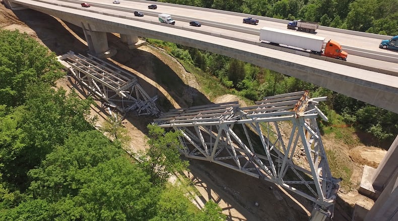The third time was not quite the charm that ODOT officials were expecting as contractors tried again to take down the remaining steel structure of the Jeremiah-Morrow Bridge last weekend. For the third day, I-71 was shut down on a Sunday morning to allow explosive demolition work to be performed next to new concrete bridges that carry traffic over the Little Miami River Valley in Warren County. One stubborn steel expanse on the north side of the old bridge failed to collapse in the last round of explosive charges, leaving large pieces of the structure intact and still attached to the concrete piers. Chunks of steel structure from the south side of the bridge are being trucked away daily. TY GREENLEES / STAFF
