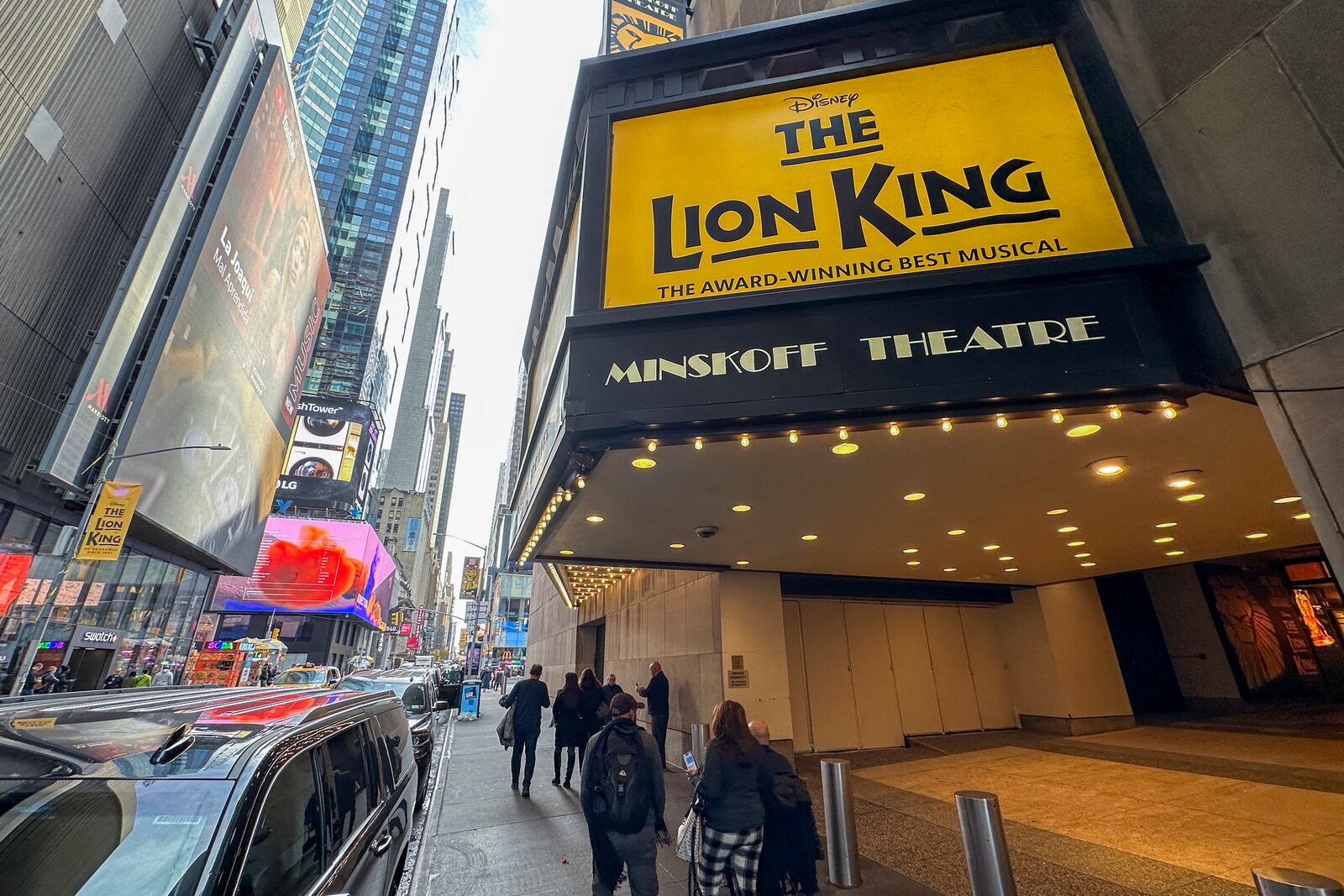 FILE — People walk in front of the Minskoff Theatre where "The Lion King" plays on Broadway in New York, Nov. 16, 2023. (AP Photo/Ted Shaffrey, File)