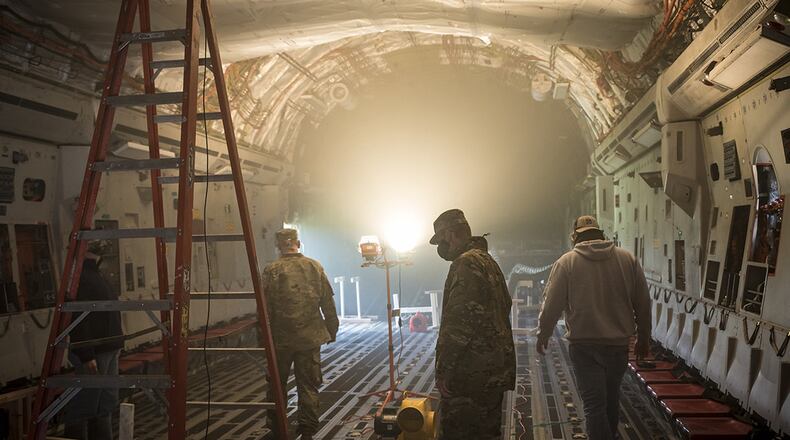 Air Force Research Laboratory team members look over a C-17 used to investigate the ability of ground heaters to raise interiors to temperatures sufficient to kill the COVID-19 virus. This test is part of an overall effort to demonstrate the effectiveness of using common equipment to disinfect aircraft quickly and easily at virtually any military installation. (U.S. Air Force photo/Richard Eldridge)