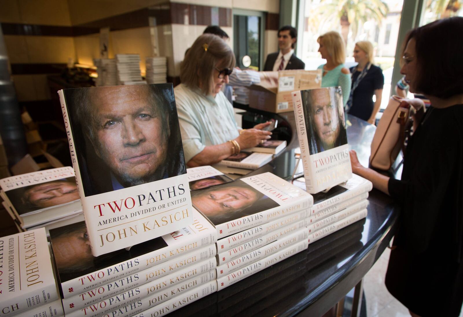Ohio Gov. John Kasich sold his new book, “Two Paths: America Divided or United,” after speaking at Forum Club of the Palm Beaches in West Palm Beach, Florida on Friday, May 26, 2017. (Allen Eyestone / The Palm Beach Post)