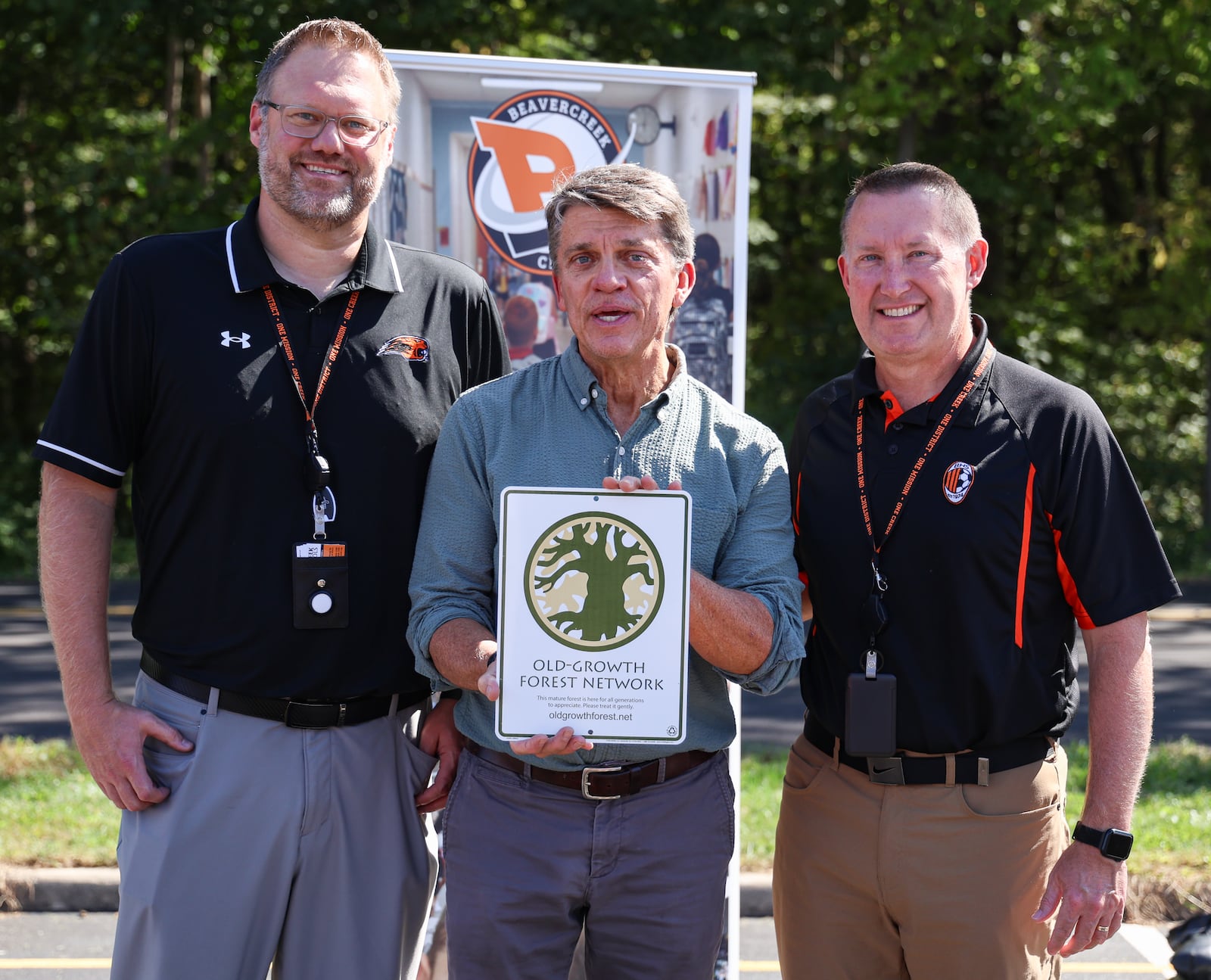 Brian Kane, a regional manager for Old-Growth Forest Network, talks while presenting a plaque to Beavercreek City Schools business services director Tyler Alexander (left) and superintendent Paul Otten (right) during a ceremony on Wednesday, Oct. 1 at Beavercreek High School. Ferguson Land Lab was added to Old-Growth Forest Network. BRYANT BILLING / STAFF
