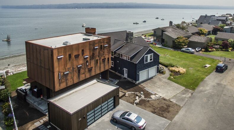 Every home in this photo is owned by members of Megan McMurray s family. The contemporary home on the left, designed by architect Erich Remash, belongs to Megan and her husband, Mike McMurray, and her sister and her family. Mike s father, Al McMurray, built the home. When my dad got the plans, he said, Can t you build something easier? Mike says. It was a challenging build. (Steve Ringman/Seattle Times/TNS)