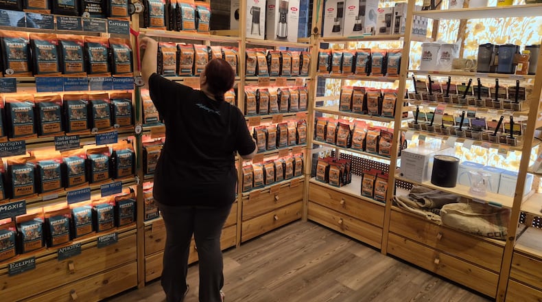 A clerk works with displays at Poppets Coffee and Tea's 2nd Street Market location. Poppets is opening a new location Oct. 13 in spite of tariff uncertainty. Michael Kurtz / Staff