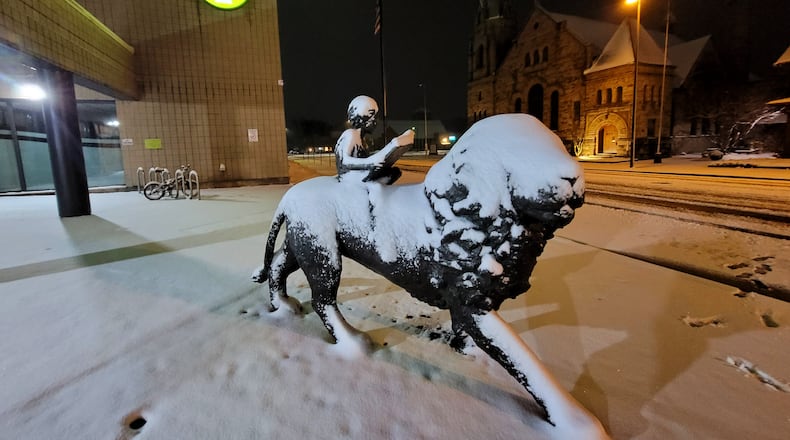 Snow covers the lion statue at MidPointe Library Friday evening. Feb. 16, 2024 in Middletown. NICK GRAHAM/STAFF