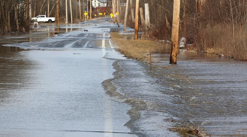 Several inches of rain flows across Spangler Road in Clark County forcing the County to close it due to all the rain Thursday. BILL LACKEY/STAFF