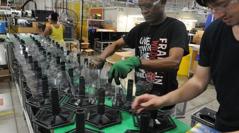 Employees of Innovative Plastic Molders assemble birdfeeders. The company manufactures all the plastic parts in house. MARSHALL GORBY\STAFF